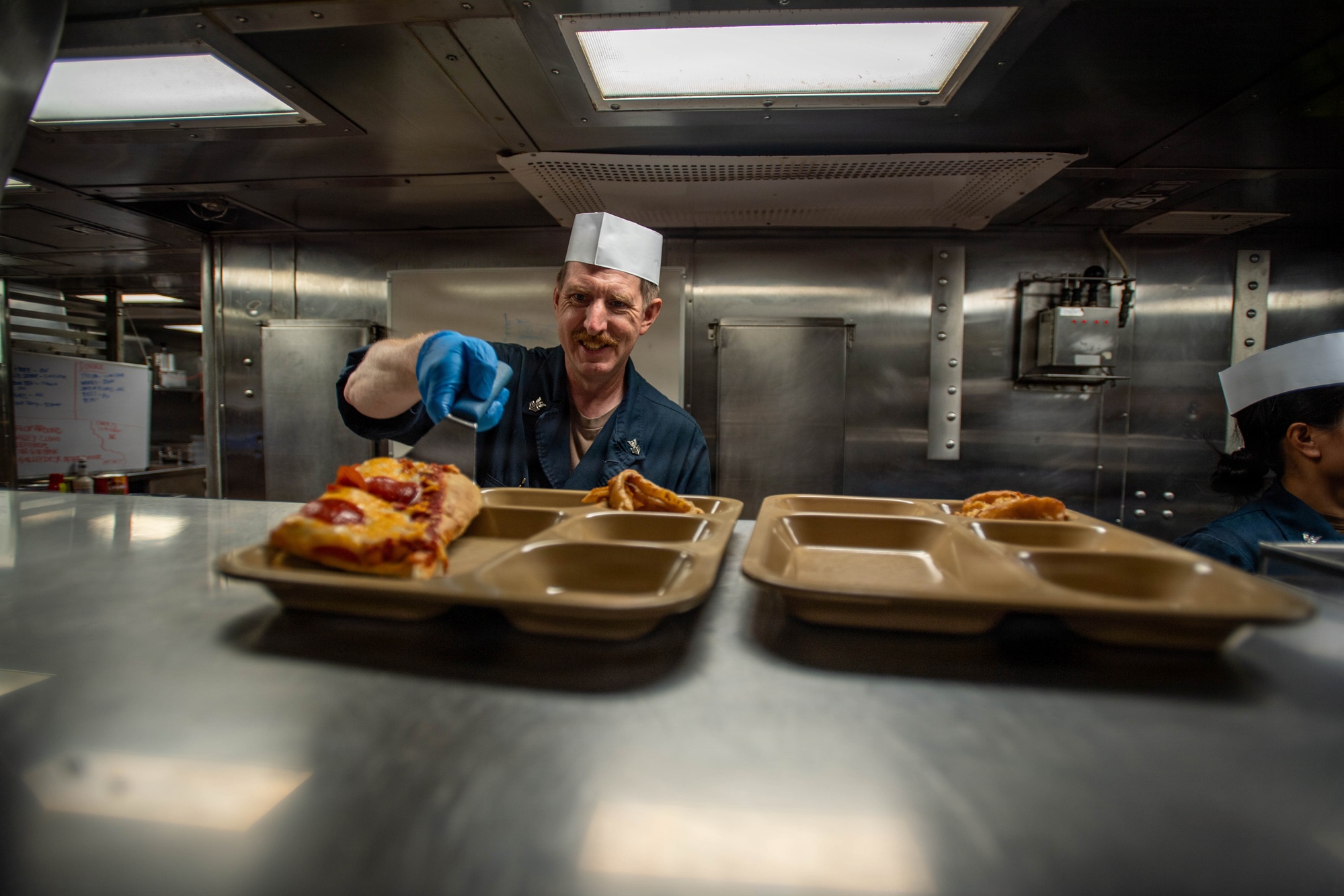 Navy sailor serving food on the mess line aboard USS Gridley (DDG 101)